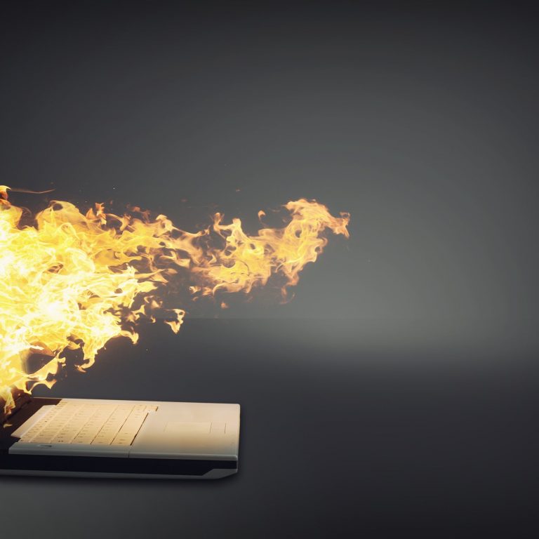 Laptop on fire isolated gray background.
